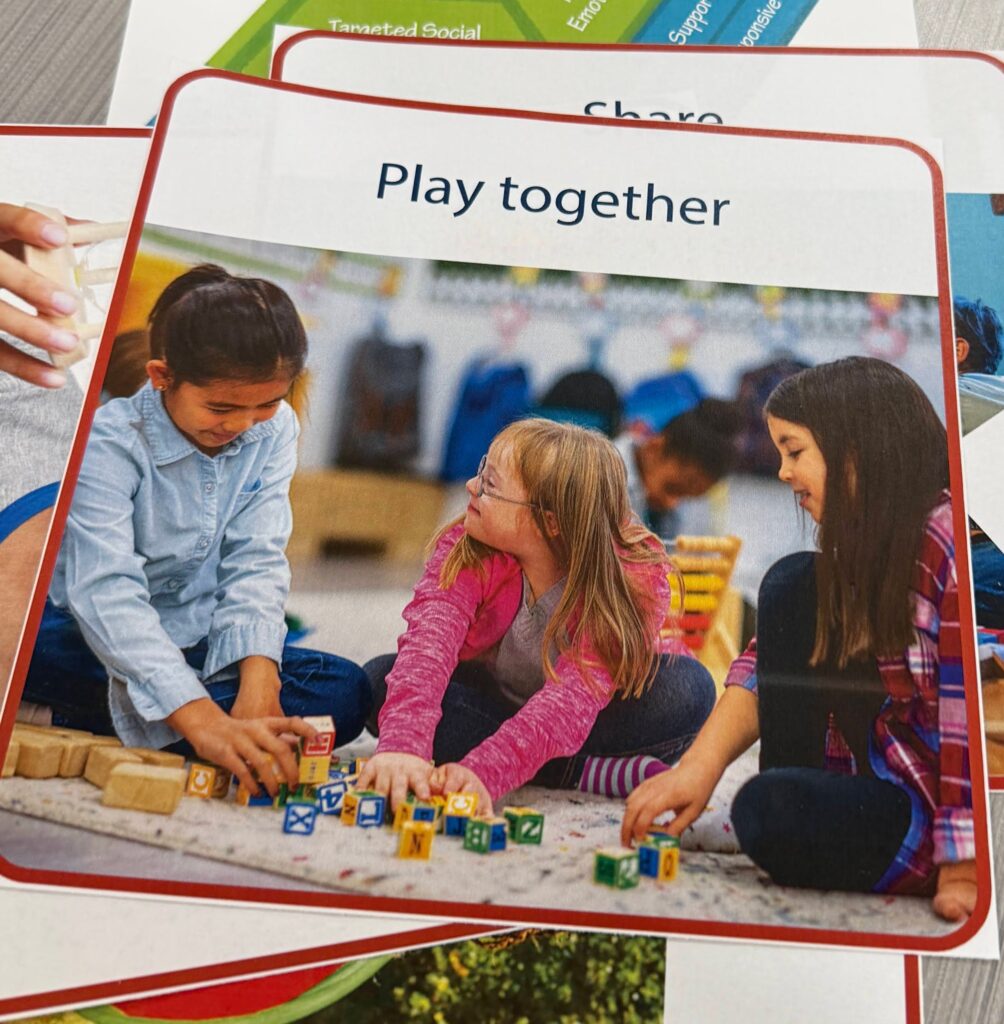 Card showing "Play together" and children playing togehter.